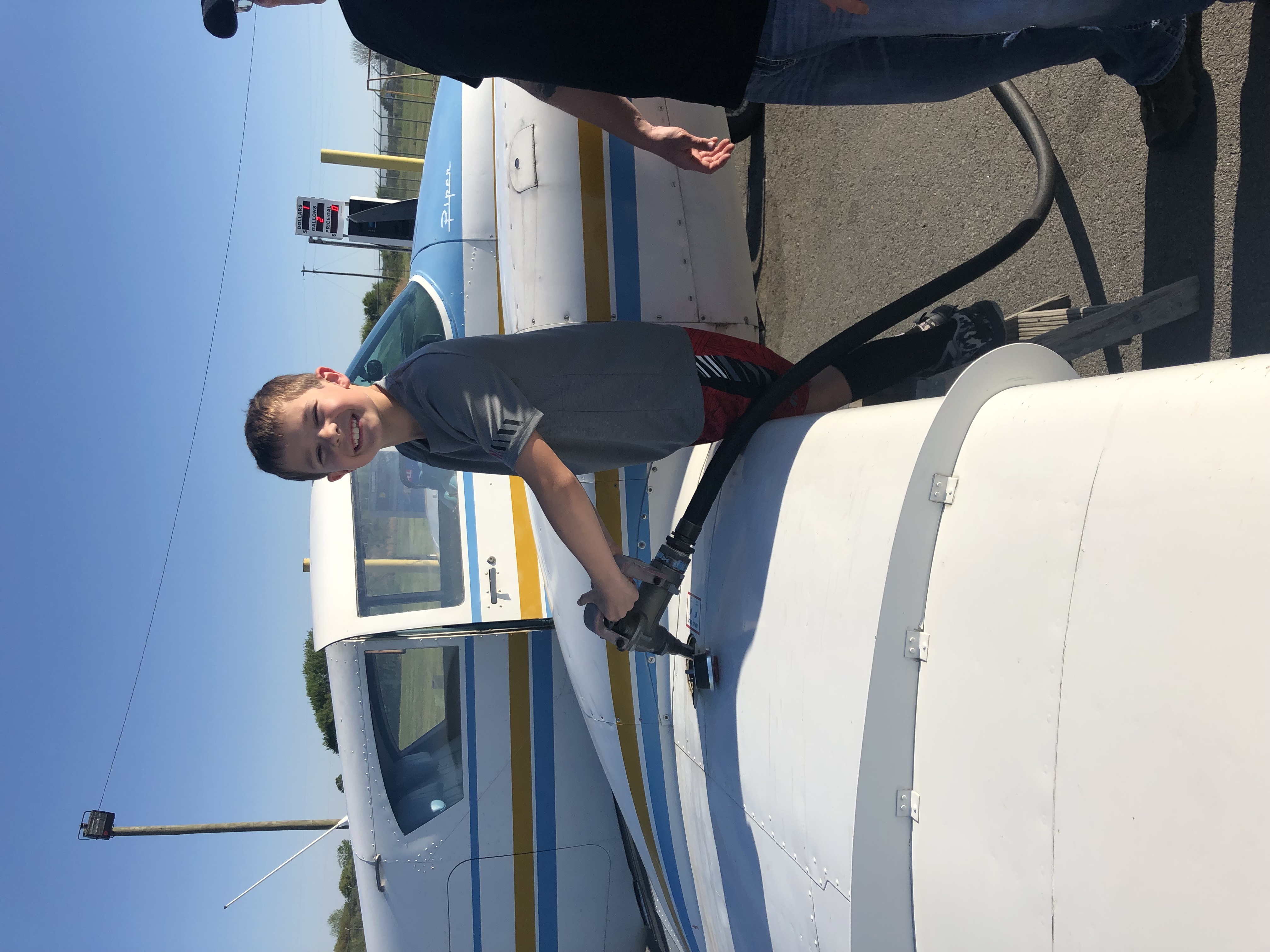 Young aviator helping fuel a Piper aircraft